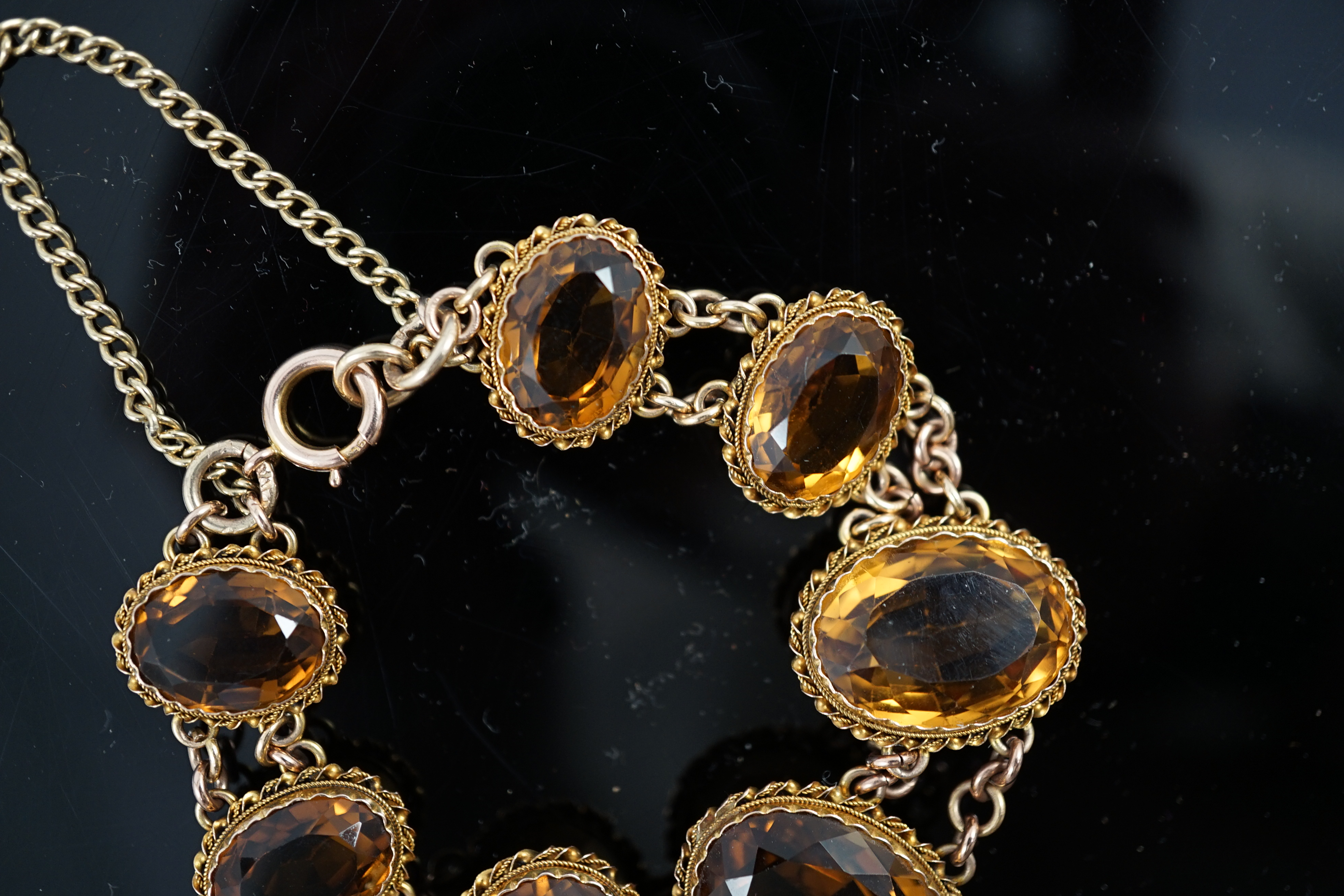 An early 20th century 9ct gold and graduated seven stone oval cut citrine set bracelet